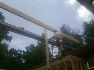 Carpenter setting a ridge beam over a new addition frame — Ice Dam Removal by Roofing Brothers in Tabernash